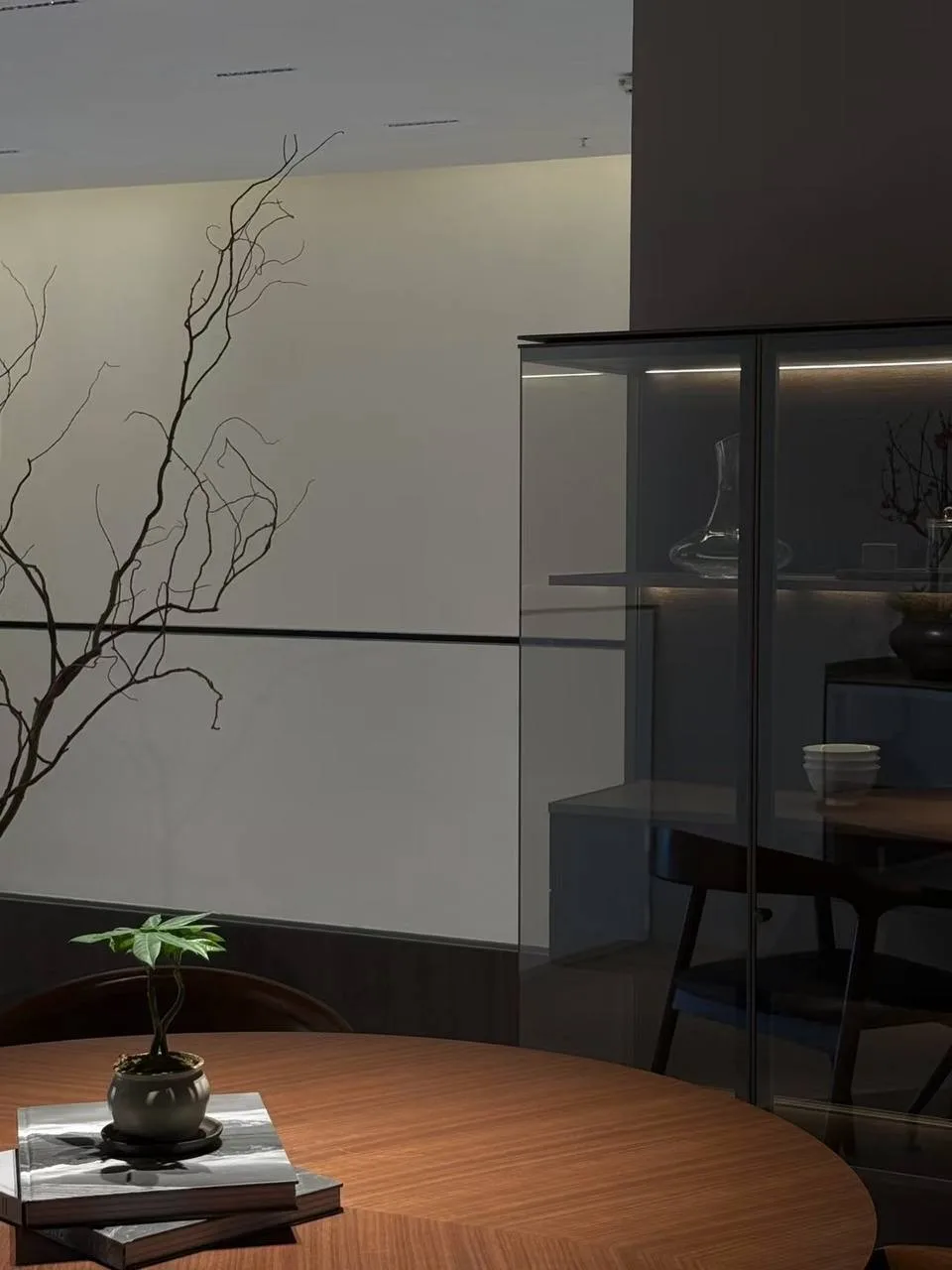Walnut dining area with backlit glass display cabinet