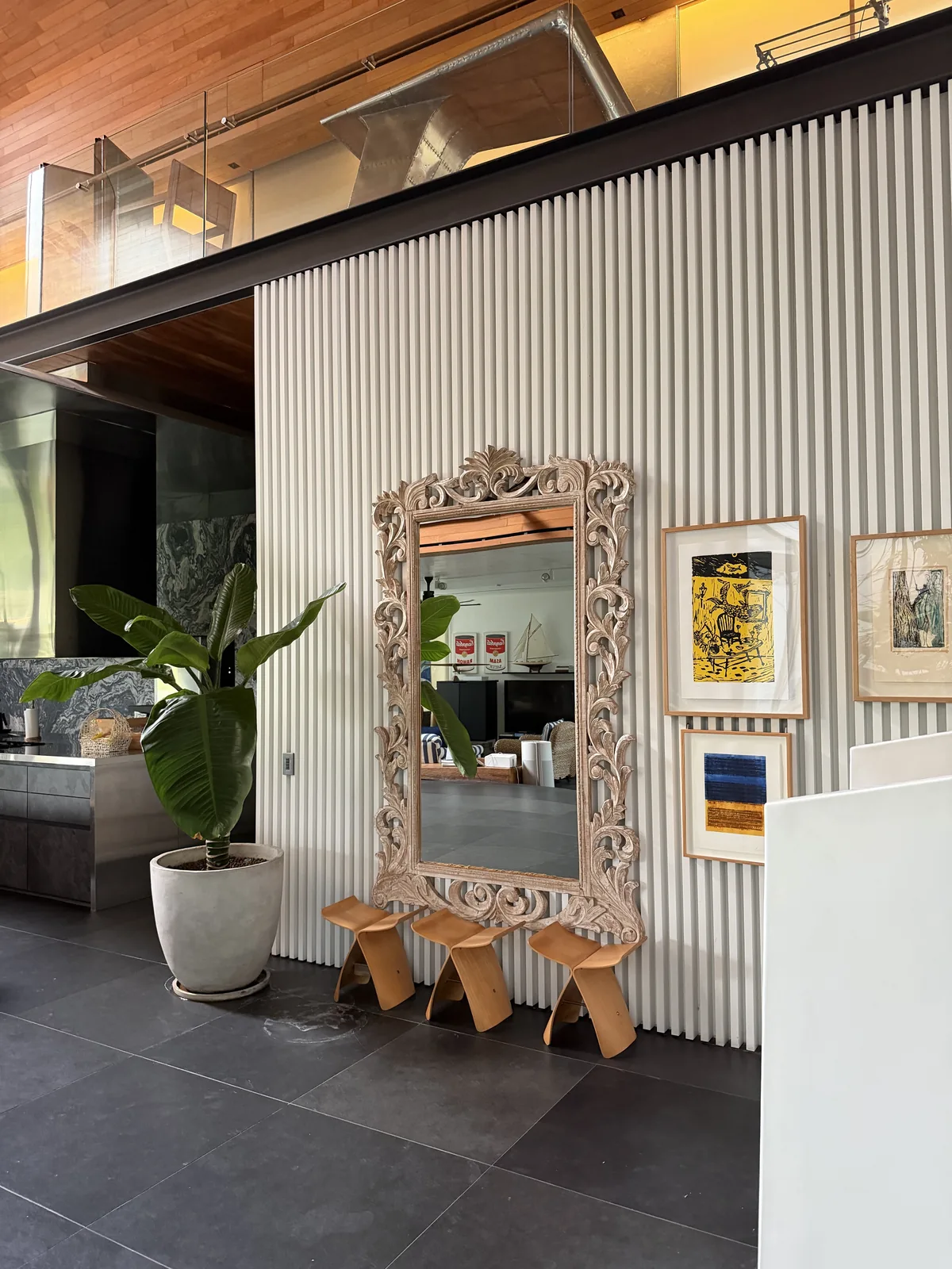 Fluted feature wall with carved timber mirror in a double-height foyer